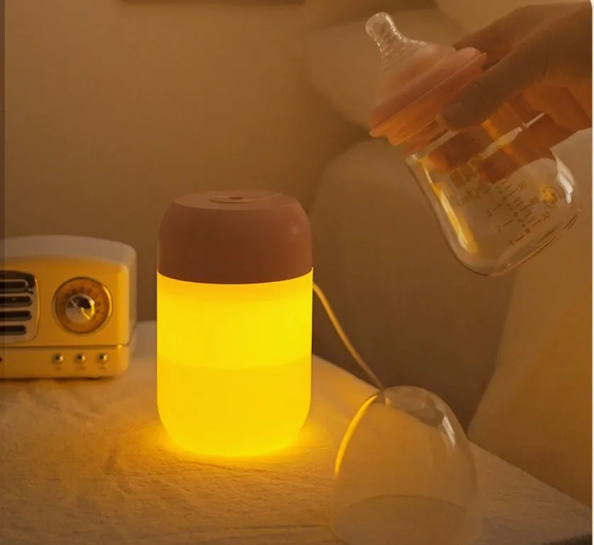 White cylindrical USB-powered mini humidifier with aromatherapy function on a wooden desk.