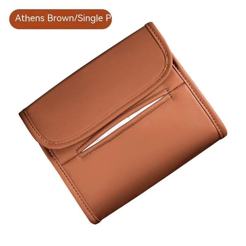 Brown leather car tissue box with elastic strap hanging on a car armrest