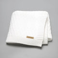 Solid colour acrylic infant hug blanket with three-dimensional lines, shown in a selection of colours.