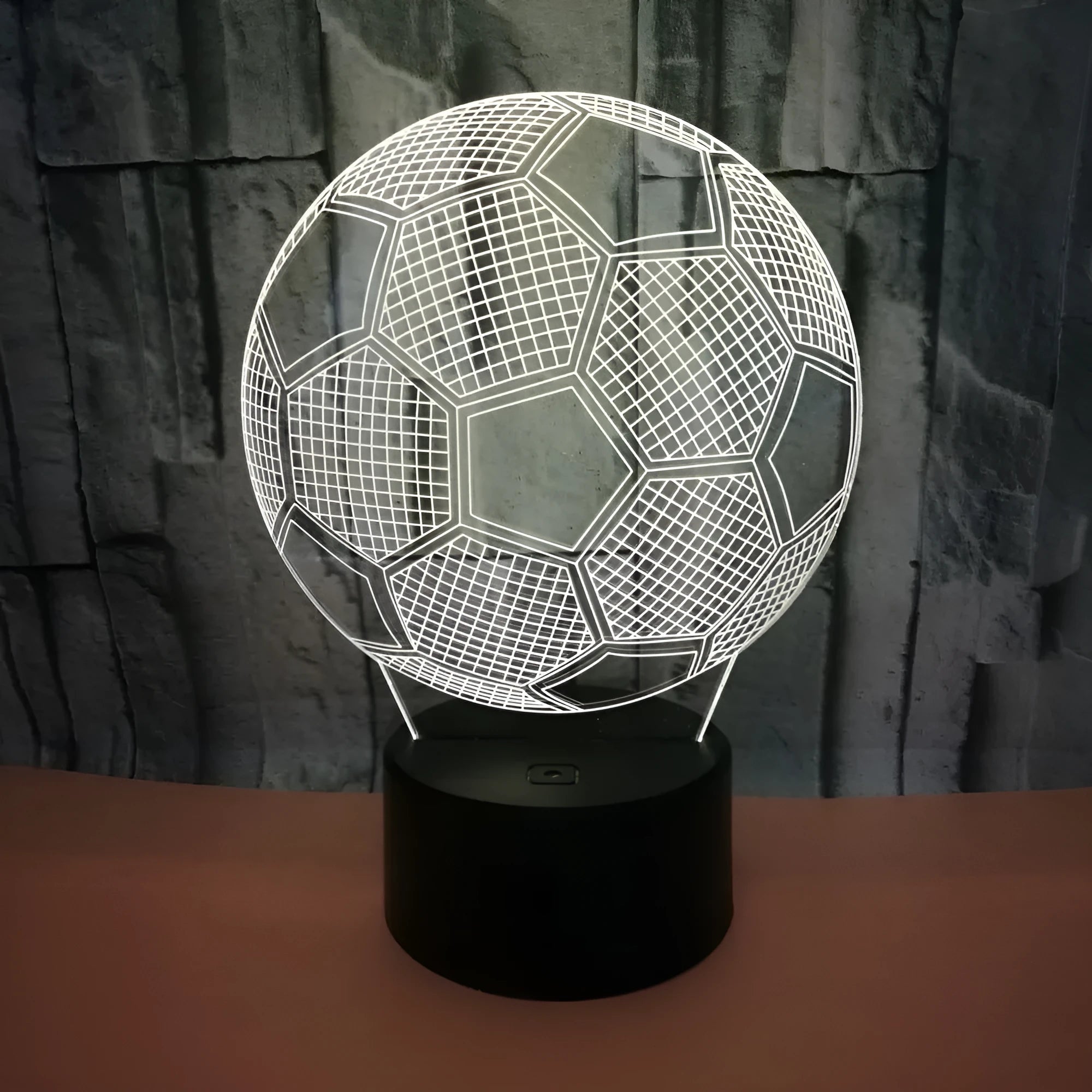 3D football shaped LED night light showing multiple colour options on a dark surface.