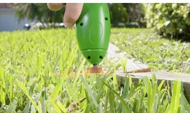 Cordless Zip Trim lawn trimmer with extension pole and protective shield on a garden lawn