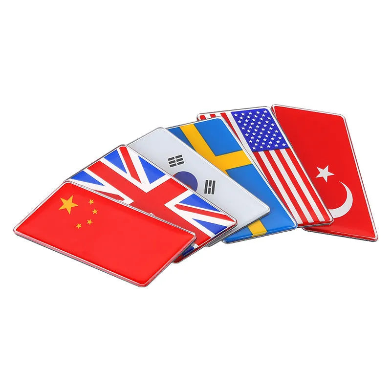Aluminium national flag car sticker in a parallelogram shape measuring 6.3 by 3 centimetres.