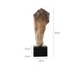 A tall, abstract white horse head sculpture with a carved surface texture on a shelf.