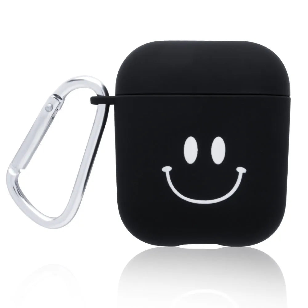 Black AirPods hard case with a smiley face design next to a pink case with a flower pattern.