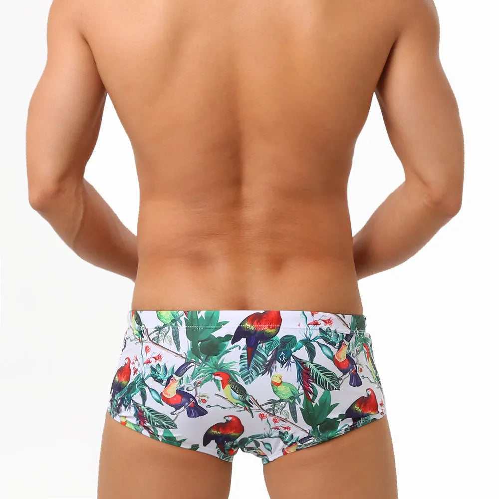 Men's swimming trunks with a colourful floral and bird print, shown in briefs and boxers styles.