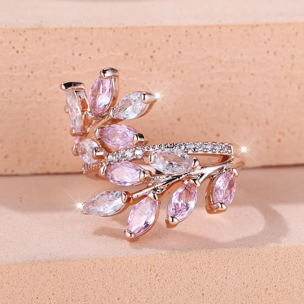 Copper leaf-shaped fashion ring with zircon details and an adjustable opening, shown in a rose gold finish.