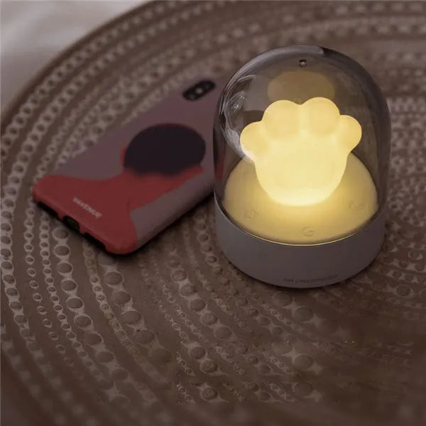 Grey and pink cat paw shaped night light with USB charging cable and musical rotation feature