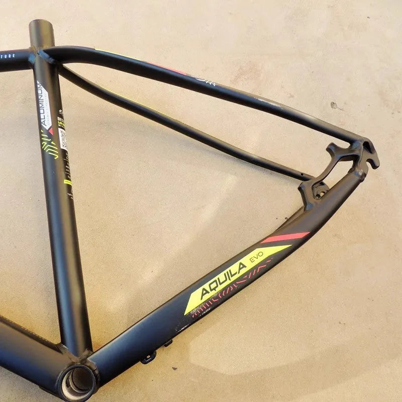 Black green aluminium mountain bike frame for 29-inch wheels with internal cable routing and disc brake mounts.