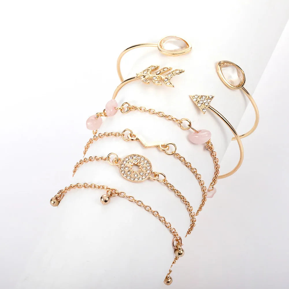Gold-coloured six-piece bracelet set with arrow and water drop shapes featuring spot drill detailing