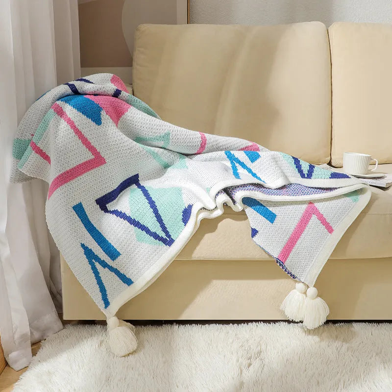 Bohemian-style acrylic sofa cover blanket with tassel trim in a geometric pattern colour option