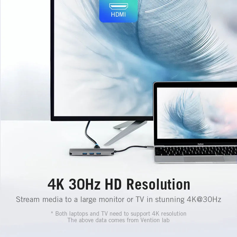 Deep grey USB-C multiport hub with HDMI, USB 3.0, Ethernet, and card reader ports on a desk.