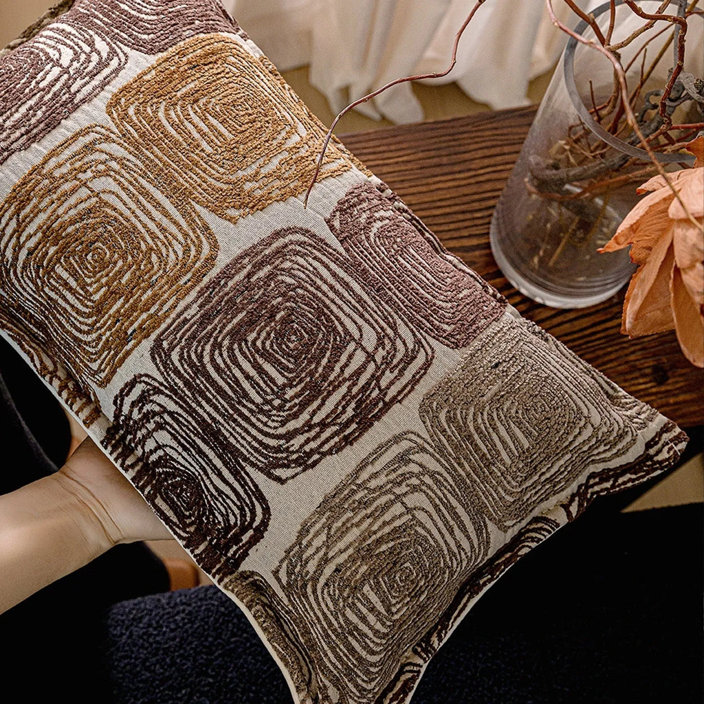 Square and rectangular decorative cushion covers with an abstract coil pattern in cream and coffee brown colours.