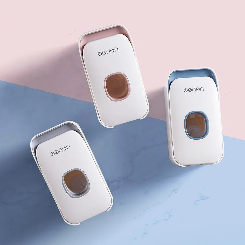 Wall-mounted automatic toothpaste dispenser in blue, grey, and pink colours