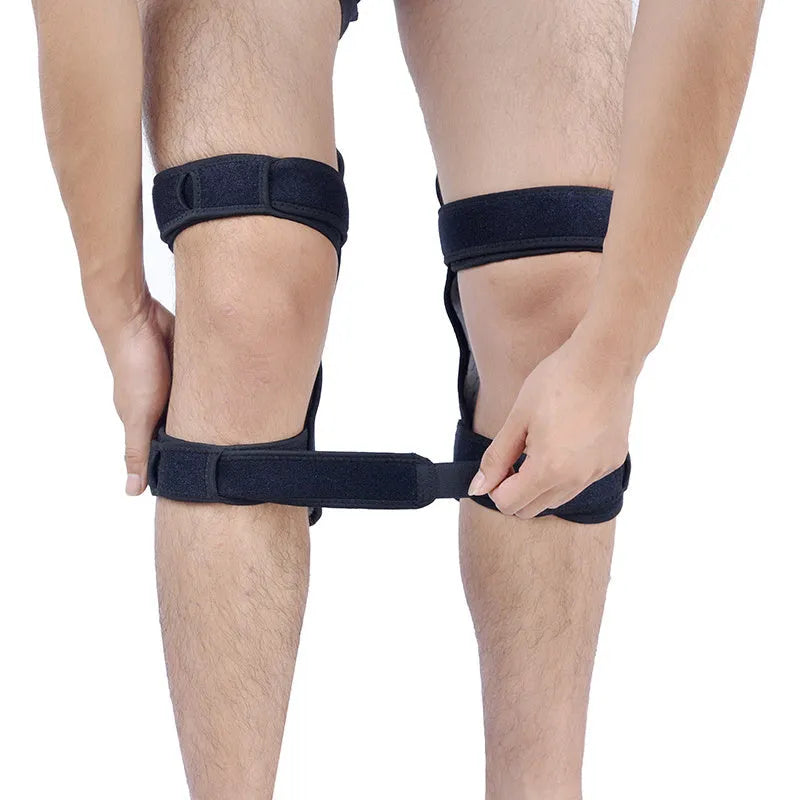 Black spring-loaded knee support brace with adjustable straps and venting holes, shown on a knee.