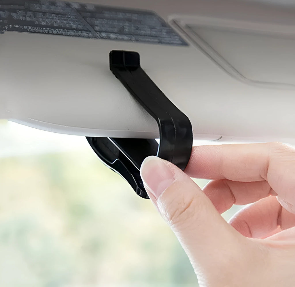 Black plastic clip for car sunshade holding sunglasses and an ID card