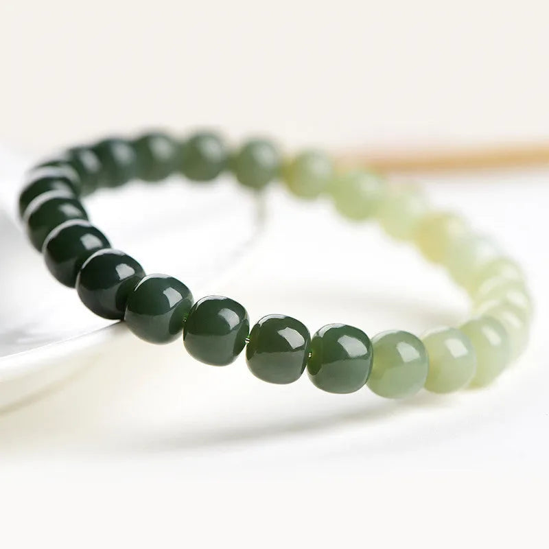 Natural Hetian jade bracelet showing gradient water colour and polished oval beads.