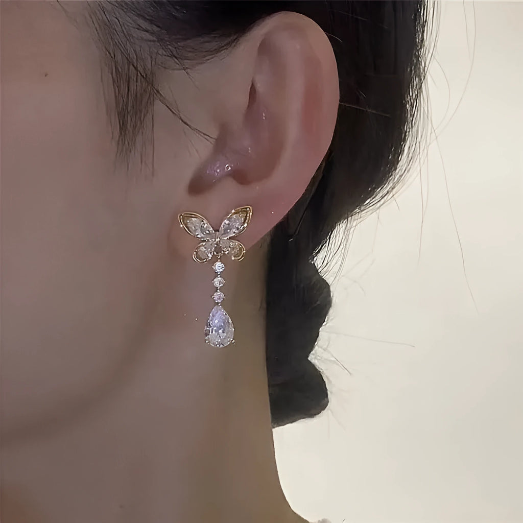 Close-up of women's platinum-coloured bow-shaped stud earrings on a zinc alloy base.