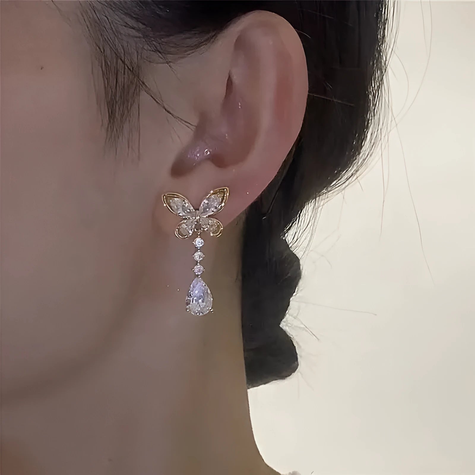 Close-up of women's platinum-coloured bow-shaped stud earrings on a zinc alloy base.