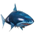 Large remote control inflatable shark balloon toy floating indoors with remote controller.