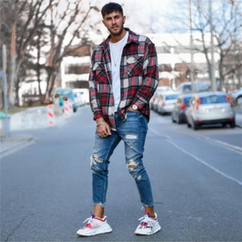 Men's distressed blue jeans with hole detailing on legs, cotton denim fabric
