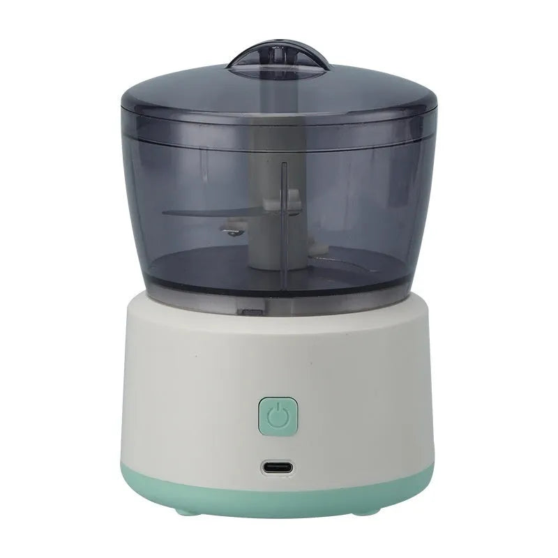 White or light green mini electric meat grinder with transparent cup on anti-slip base