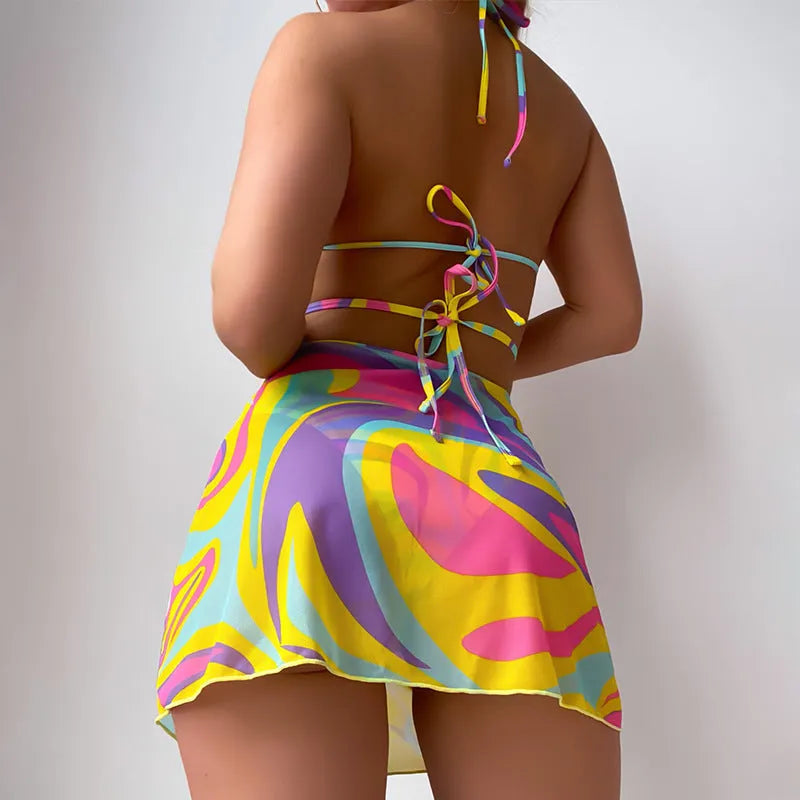 Yellow striped halter neck swimsuit with lace-up front, matching skirt, and shorts set for women.