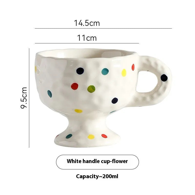 Hand-pinched irregular shaped solid colour ceramic mug on a table, showing its unique form and modern simplicity design.