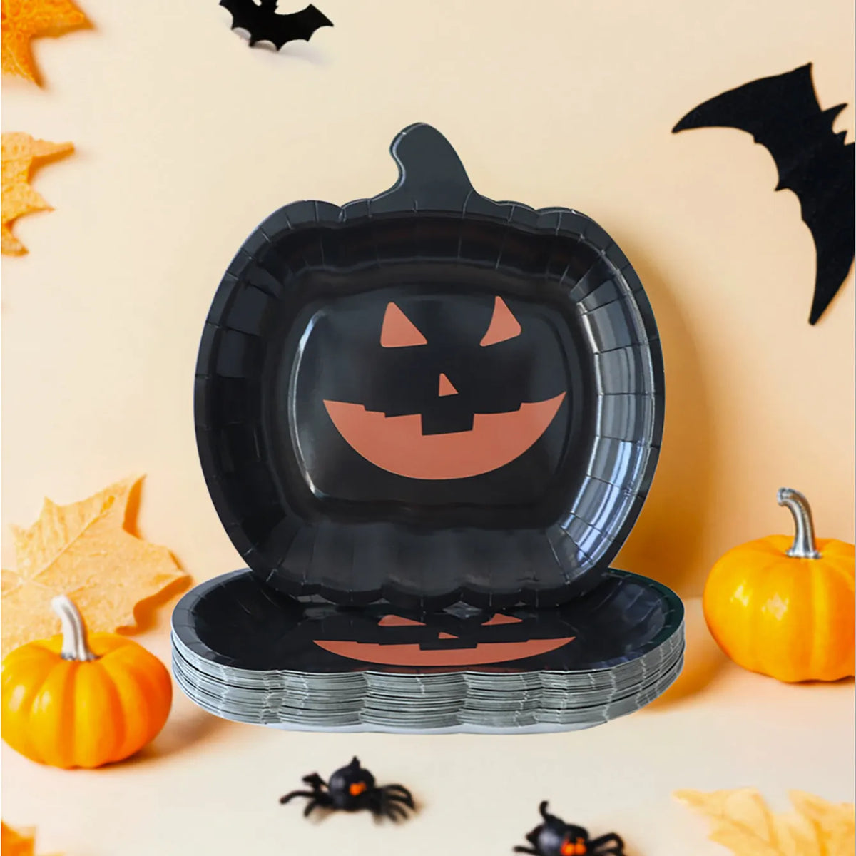 Black pumpkin design disposable paper plates measuring 9 inches in diameter, shown in Halloween party setting.