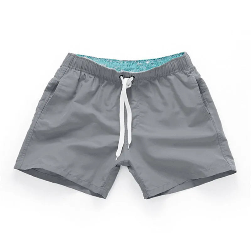 Men's polyester beach shorts in black, shown laid flat, featuring a straight leg opening.