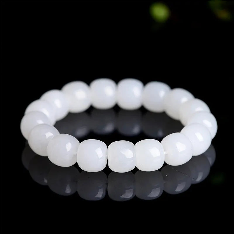 White Hetian jade barrel bead bracelet on a wrist, showing smooth beads in a unisex casual style.
