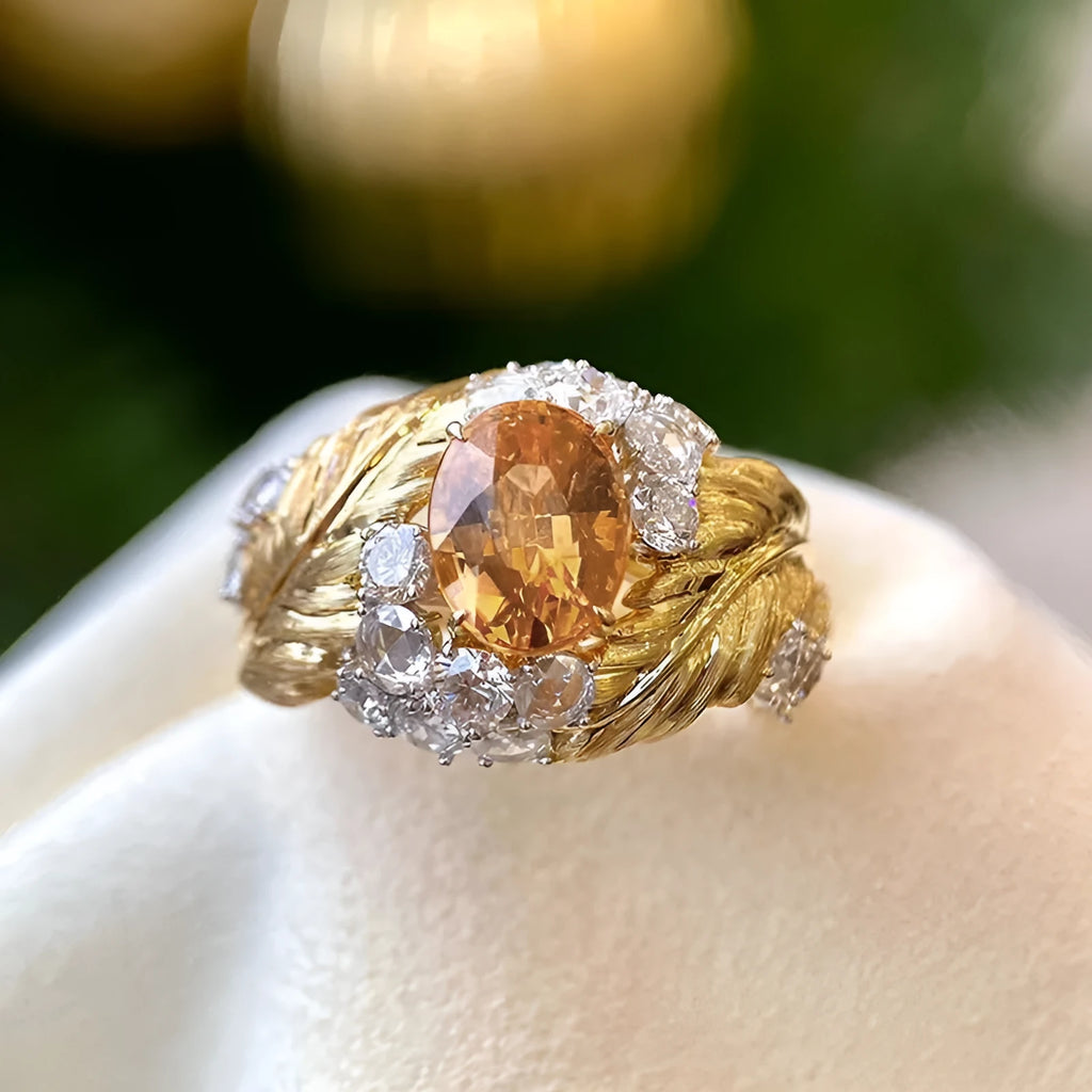 Gold-coloured women's feather ring with embossed design and yellow zircon stones on copper band