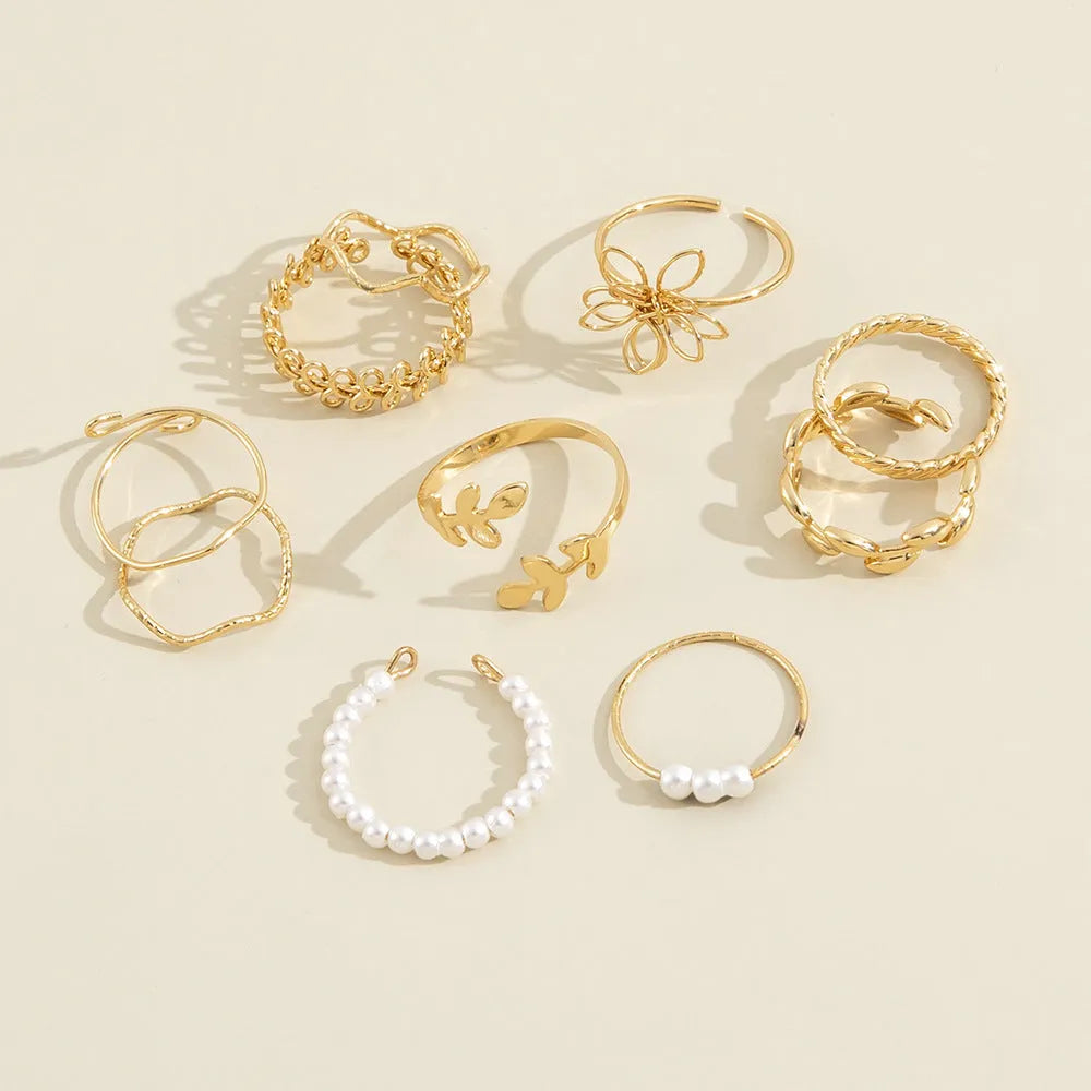 Gold coloured openwork flower design ring for women on a white background.