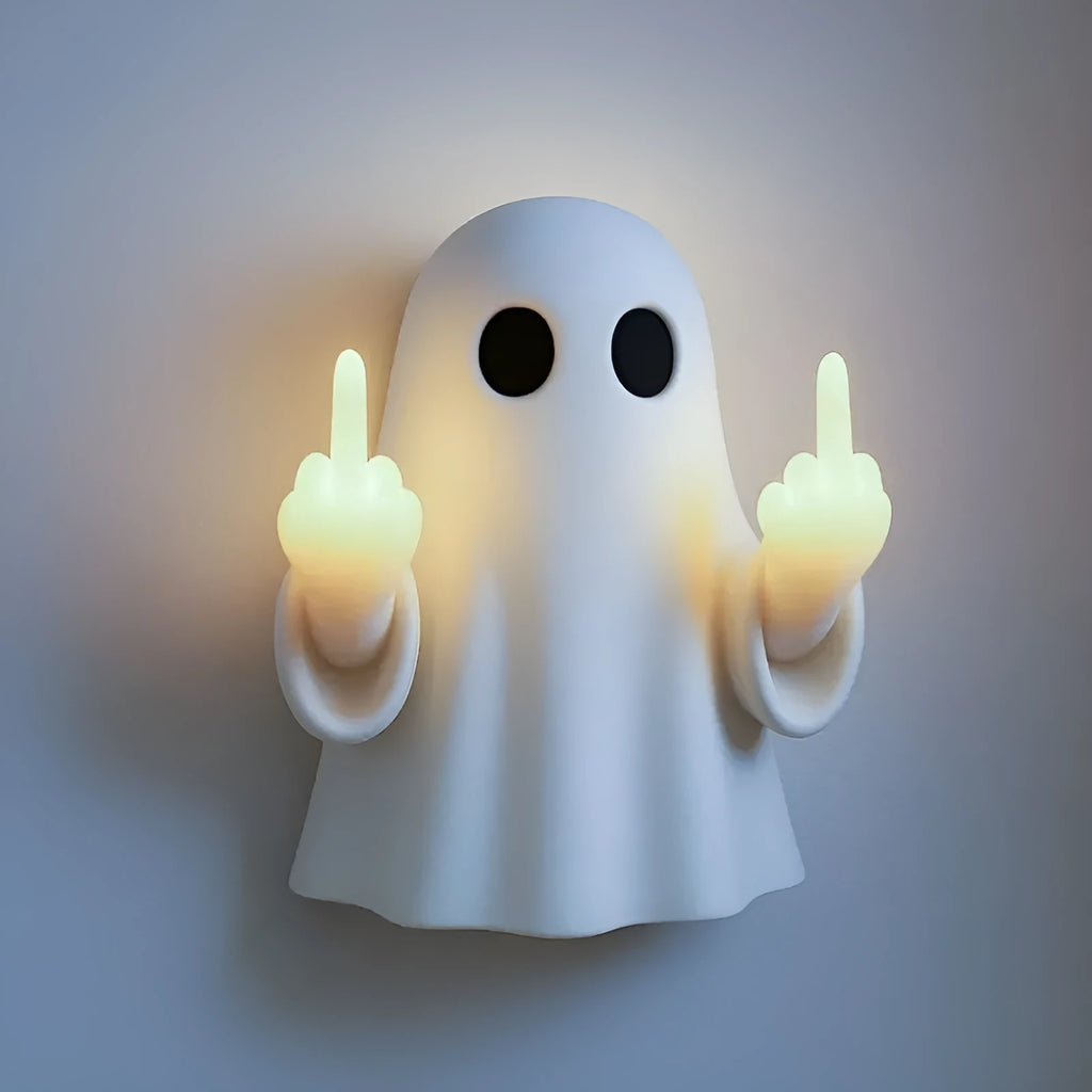 White ghost statue night lamp with LED light on a dark table.