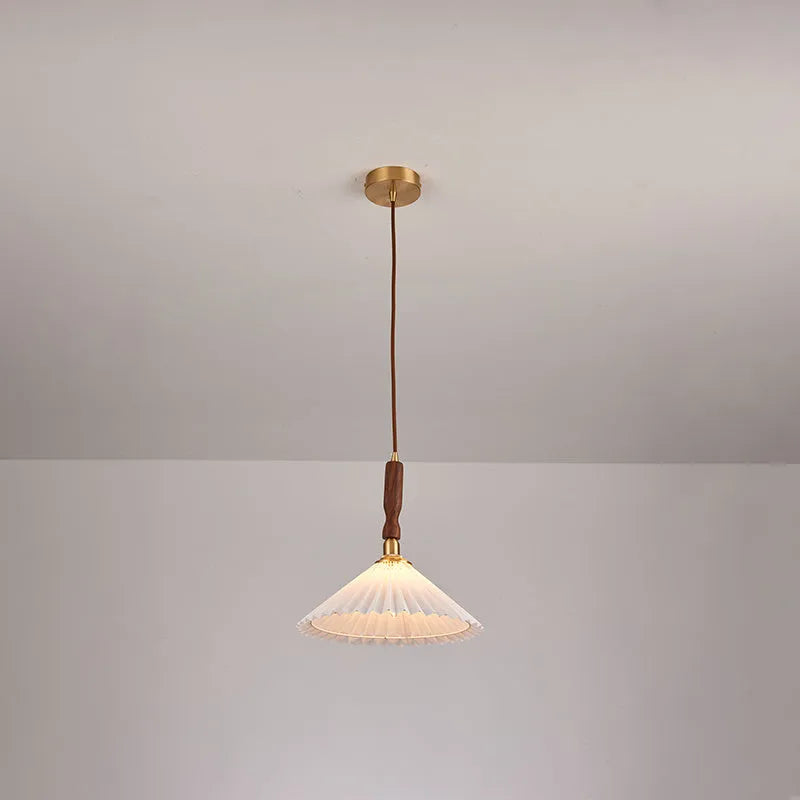 American retro-style wooden wall lamp with a fabric shade in a walnut finish on a bedroom wall.
