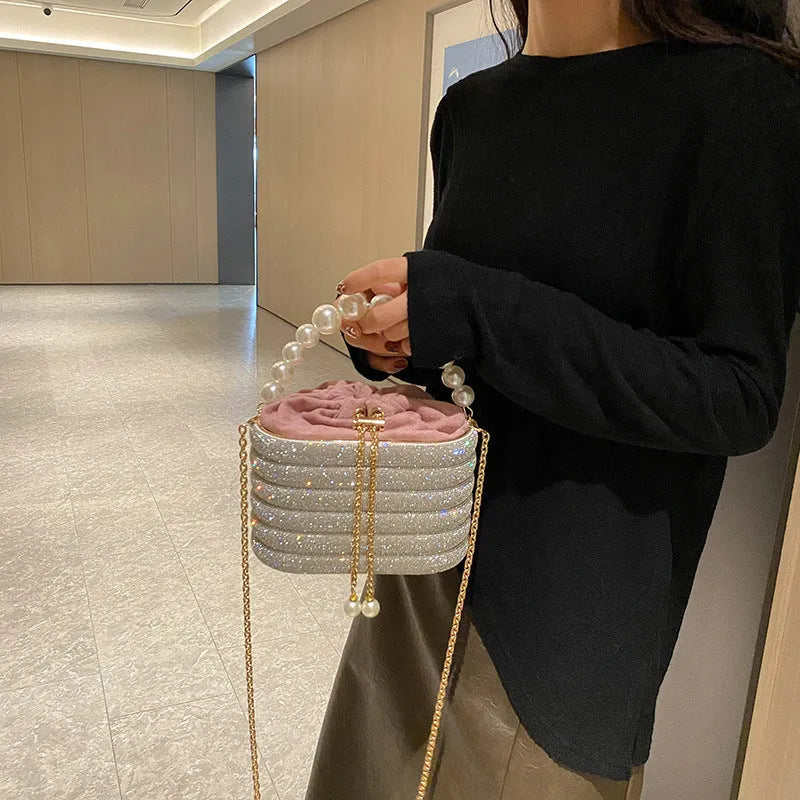 Round women's crossbody bag with beaded pearl details and single shoulder strap in retro styling