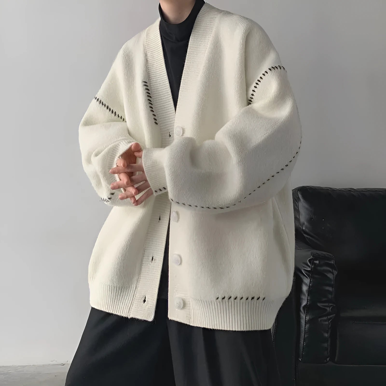 Women's loose fit knitted cardigan top coat in black or white colour with long sleeves.