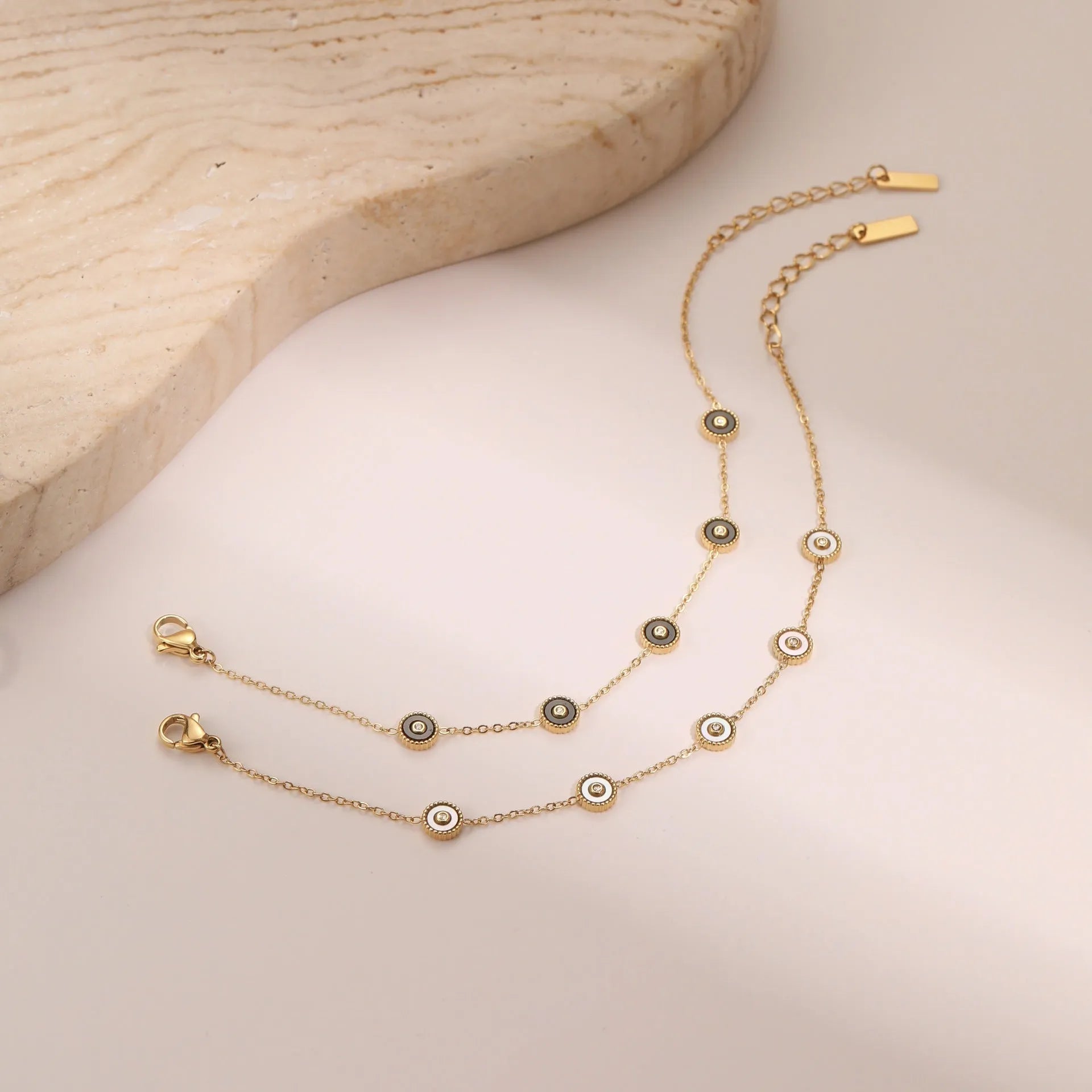 Stainless steel bracelet with 18K gold electroplating and geometric fritillary design, shown with matching necklace
