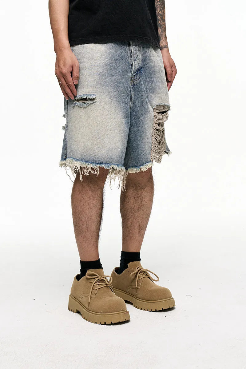 Men's light blue baggy denim shorts on a mid-waist mannequin, showing wide leg cut and zipper fly.