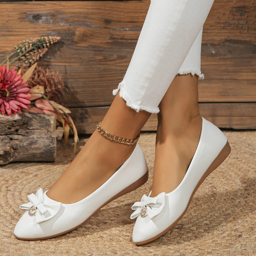 Women's beige casual flat slip-on shoe with a bowknot and round toe on a rubber sole.