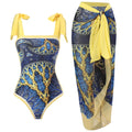 Yellow retro one-piece swimsuit with floral print and a sheer black chiffon skirt.