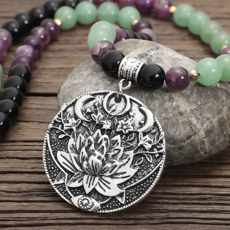 Long yoga lotus pendant necklace and matching bracelet set with stone beads and geometric design.