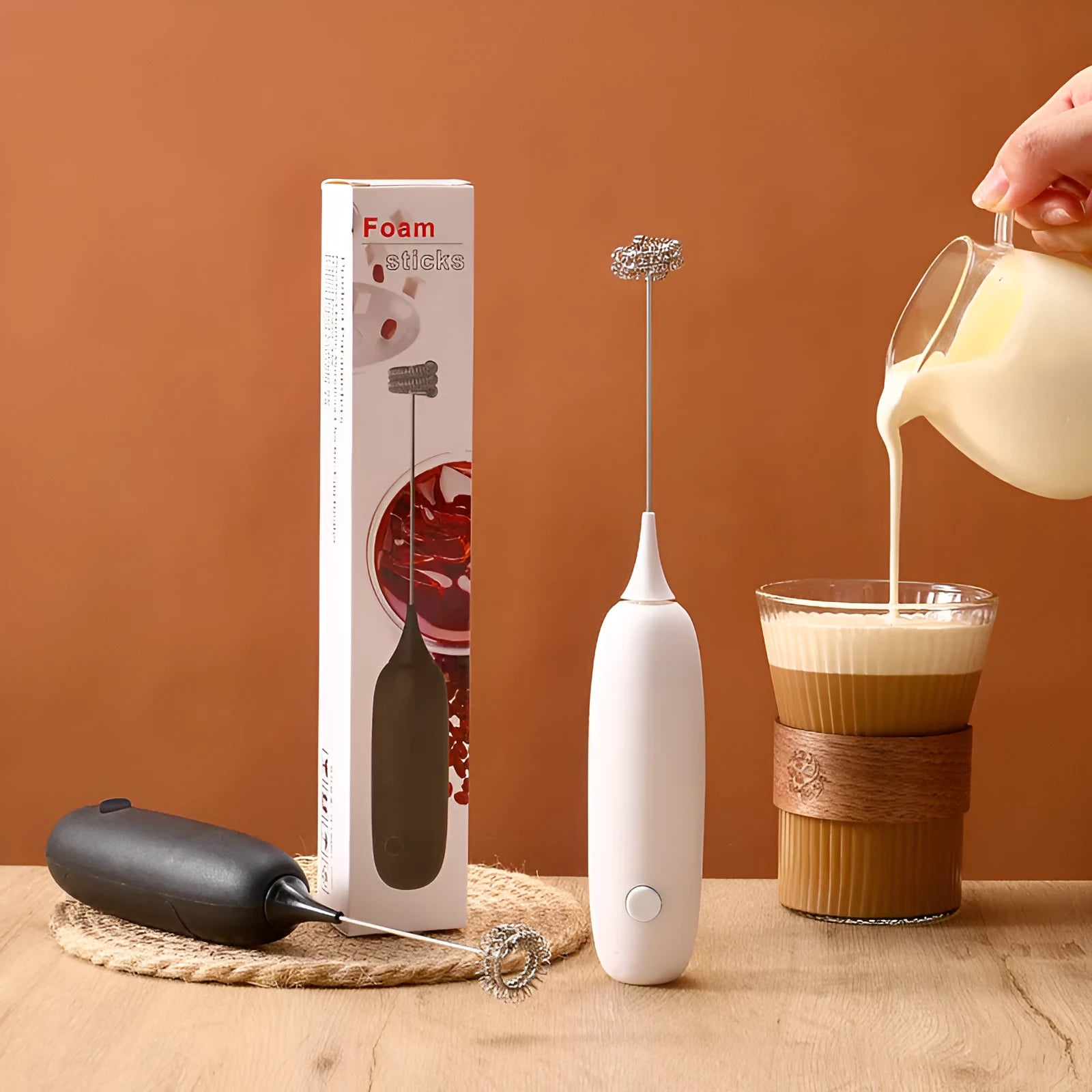 Black and white handheld electric milk frother with modern design for coffee preparation