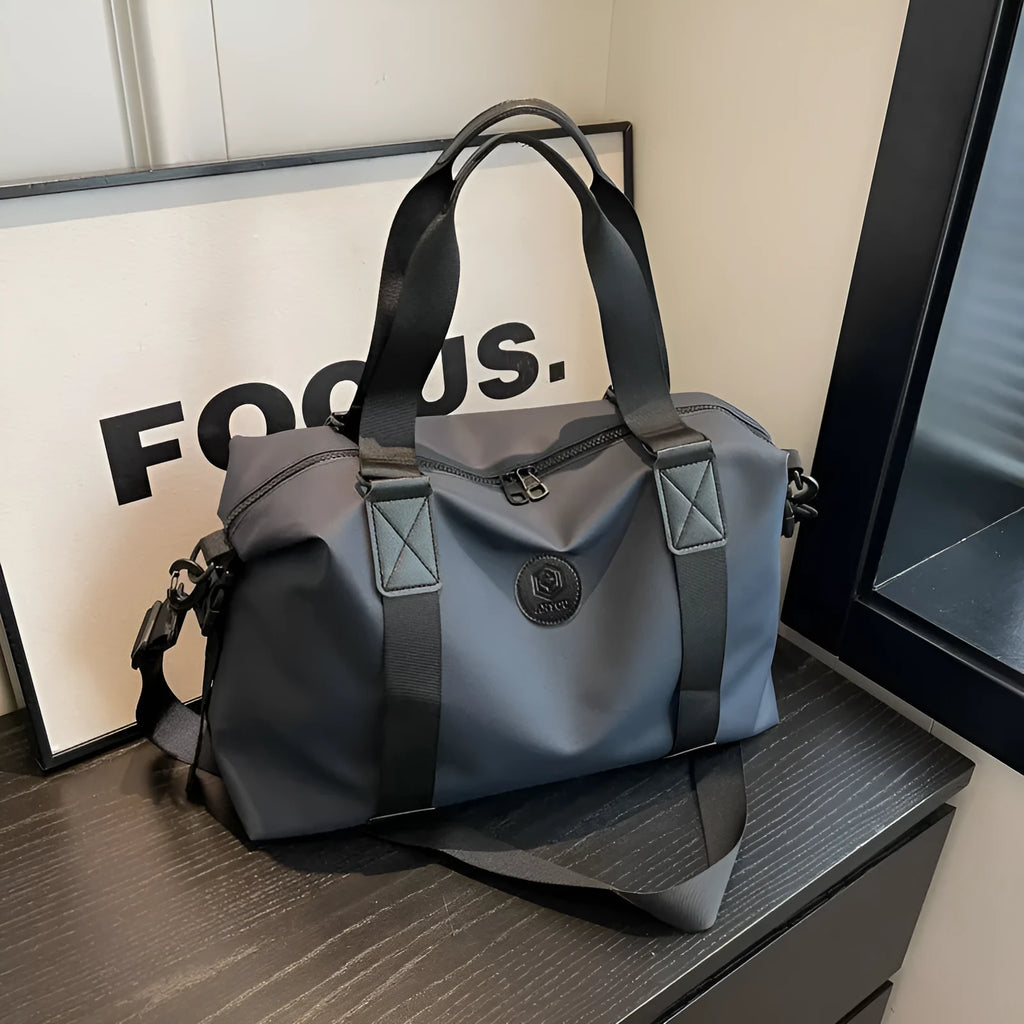 Large black waterproof Oxford cloth travel backpack with multiple compartments shown on a grey background.