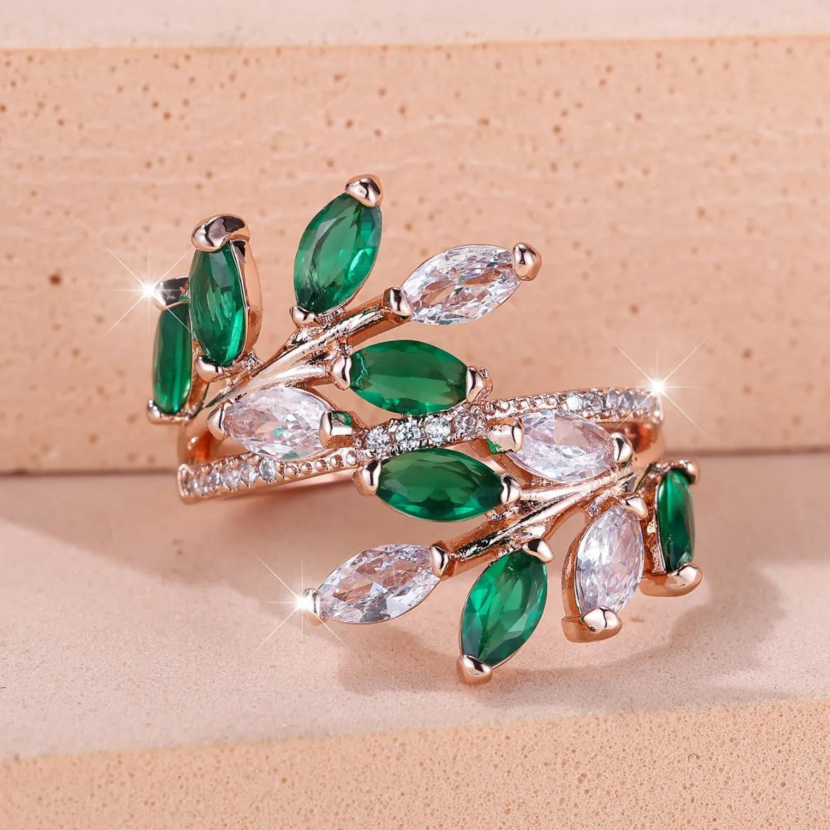 Copper leaf-shaped fashion ring with zircon details and an adjustable opening, shown in a rose gold finish.