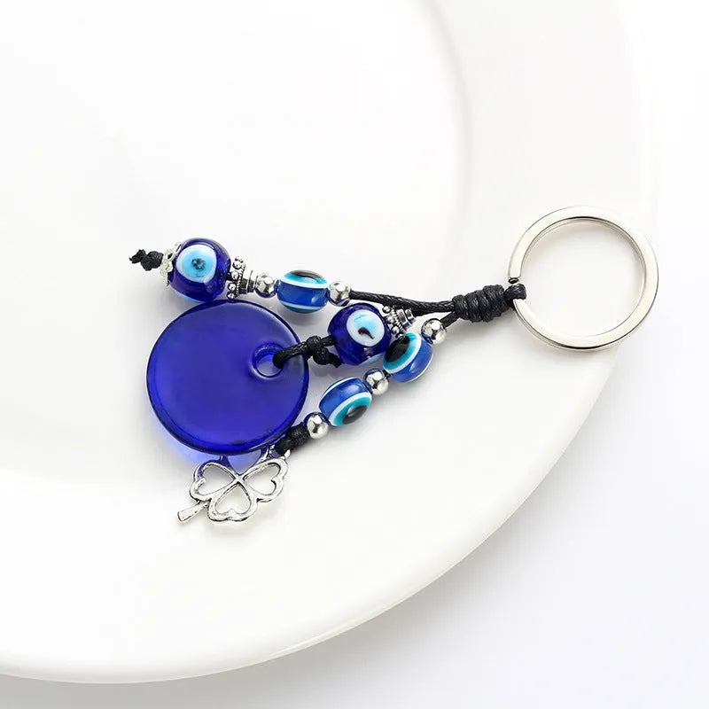 Blue evil eye keychain with metal plant-shaped pendant and unisex keyring design