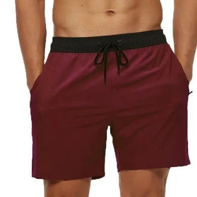 Blue men's fitness shorts with drawstring waist, pockets, and a zipper on a neutral background.