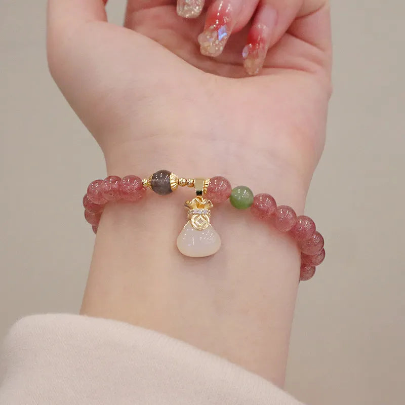 Natural strawberry quartz women's bracelet with purse charm detailing and peace buckle clasp