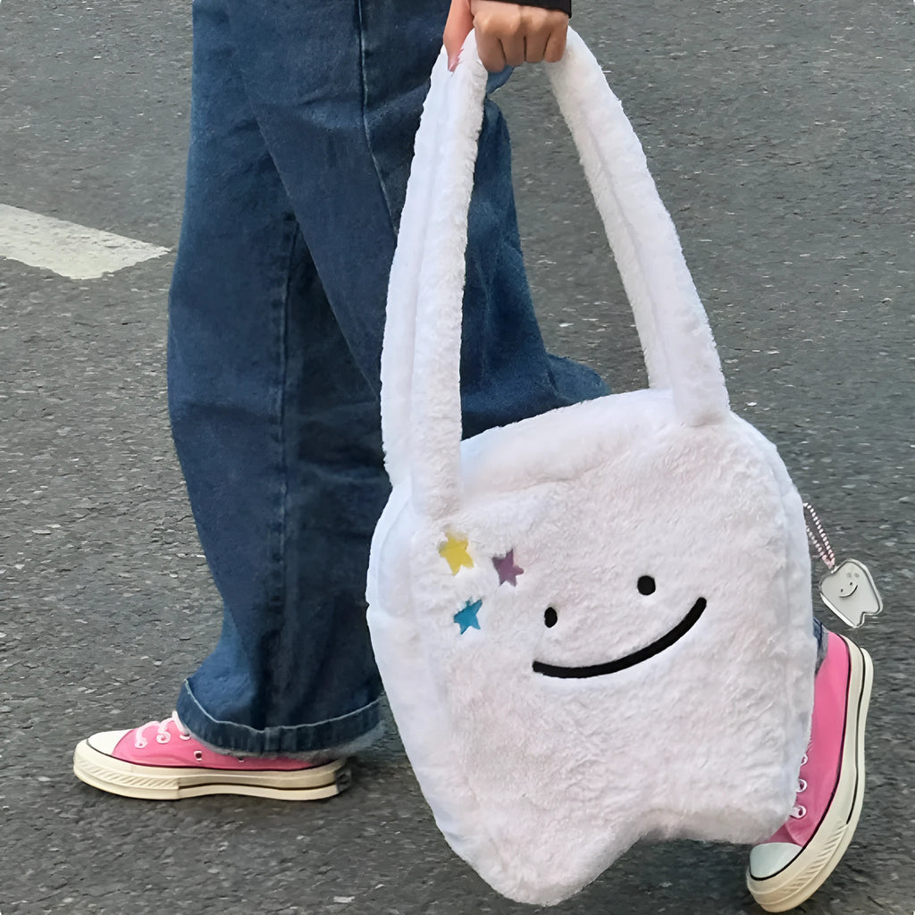 White large tote bag with plush large tooth shoulder strap and cute teeth design