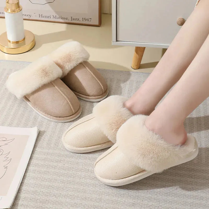 Women's plush winter slippers in pink with a round toe, flat heel, and decorative stitching.