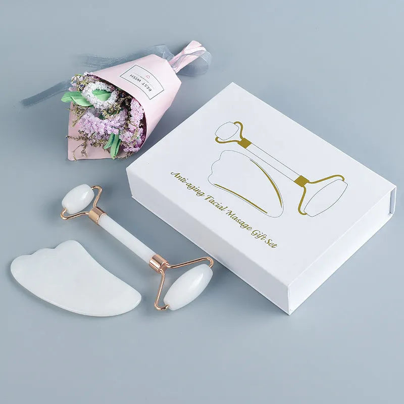Natural white jade facial roller and gua sha scraping board set on a white background.